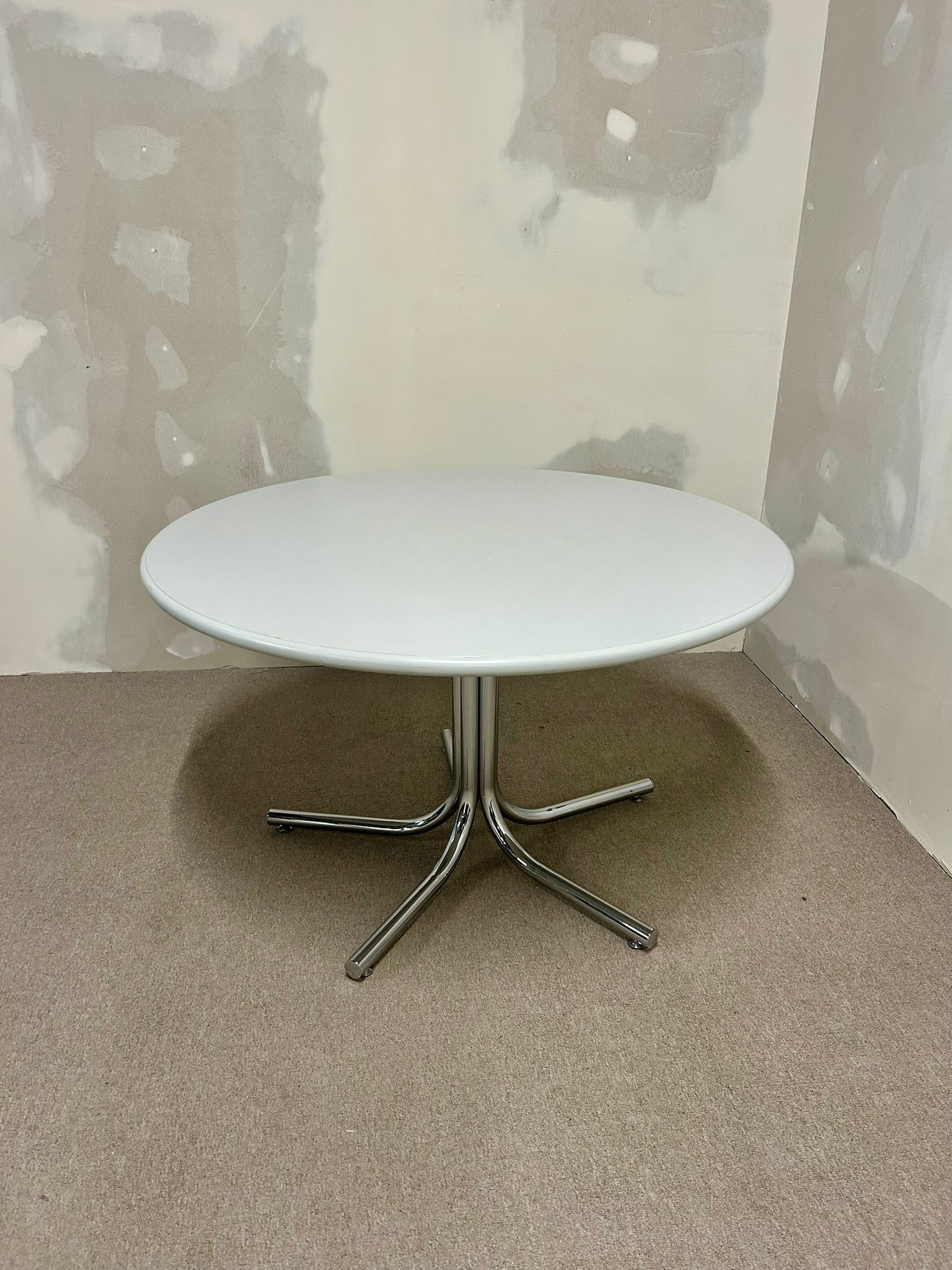 Runder Tisch mit Chrom-Füsse und grau-weisser Platte