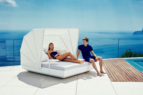 Daybed Vela de Vondom avec protection solaire installé au bord d’une piscine d’hôtel