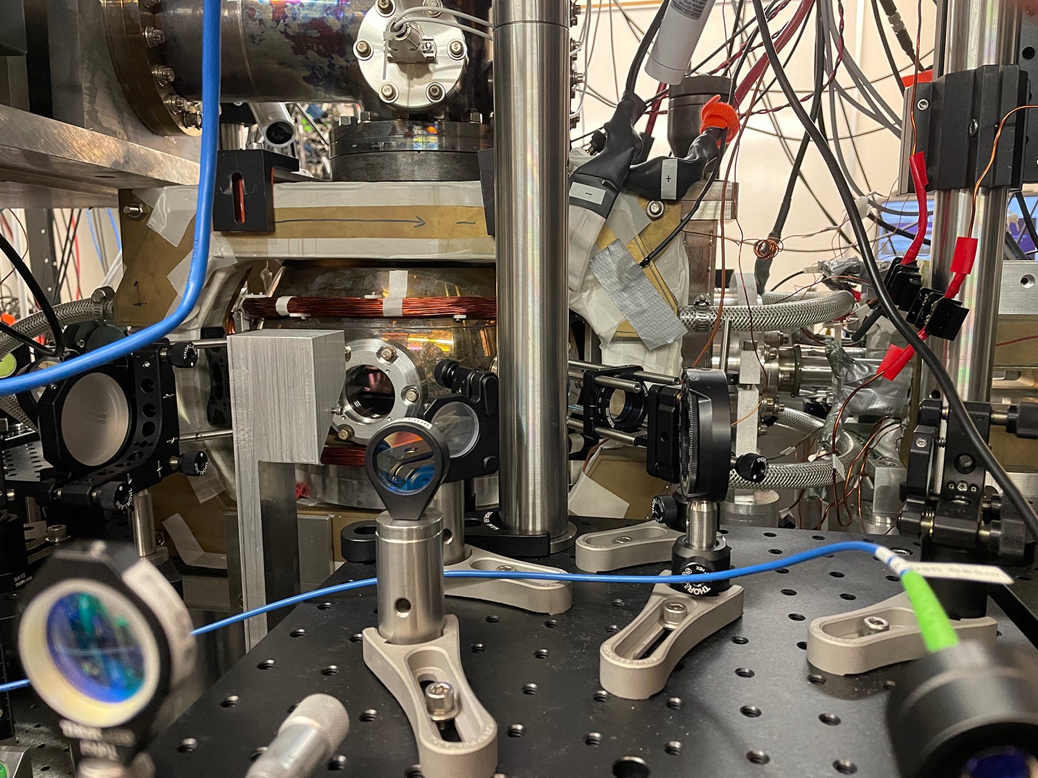 Image of the vacuum chamber on the optical table where the Stanford research team used precisely delivered light and magnetic fields to program a straight line of atoms into treelike shapes, a twisted loop called a Möbius strip and other patterns. @ Monika Schleier-Smith