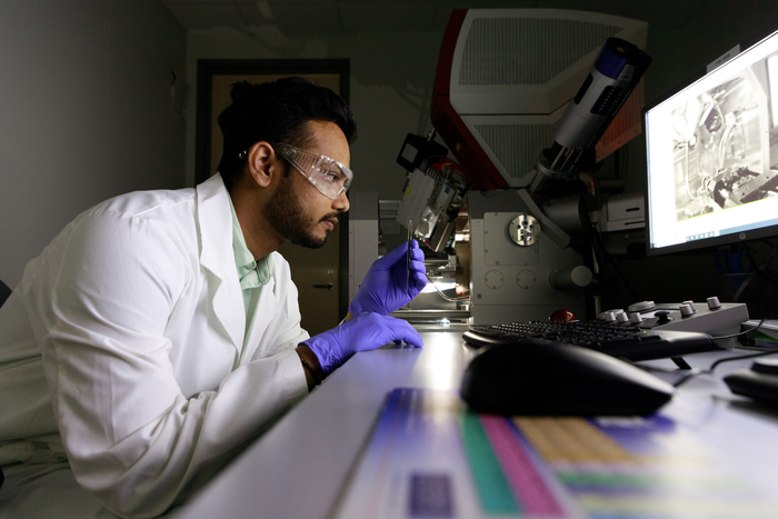Hemant Rathod observes a sample of chromium aluminum carbide before loading it into the scanning electron microscope. @ Dharmesh Patel/Texas A&M Engineering