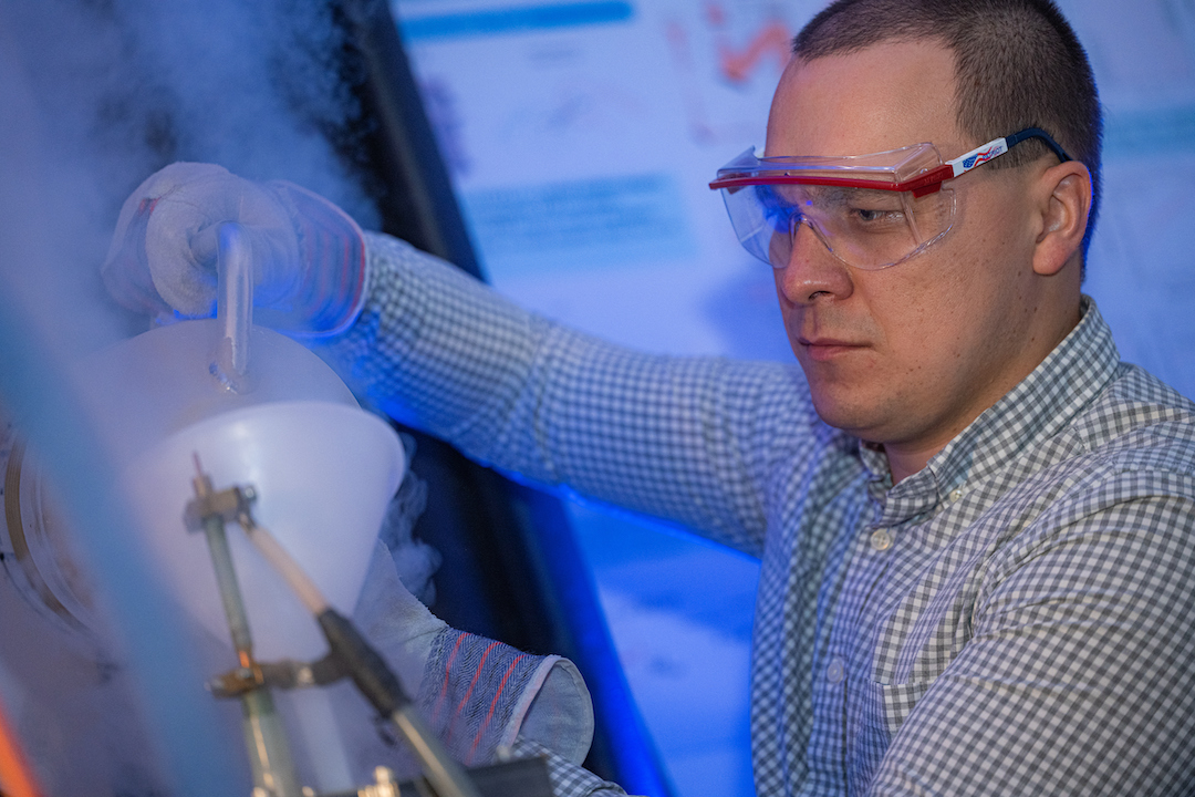 Rice University postdoctoral researcher Andrey Baydin prepares to run an experiment at RAMBO, the Rice Advanced Magnet with Broadband Optics, a tabletop spectrometer that allows materials to be cooled and exposed to high magnetic fields. The instrument helped uncover a phenomenon by which nonmagnetic phonons can be manipulated by a magnetic field. @ Jeff Fitlow