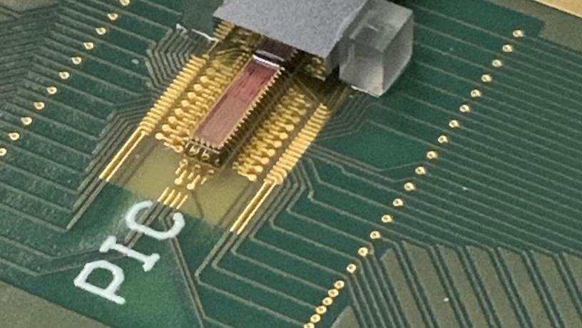 Photonic transmitter chip mounted on a printed circuit board with electrical and fiber optic connections. @ Lightwave Research Laboratory/Columbia Engineering