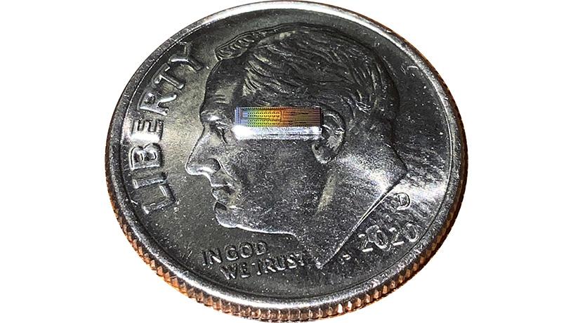 Photonic integrated chip capable of encoding data on 32 independent frequency channels on a U.S. dime for scale. @ Lightwave Research Laboratory/Columbia Engineering