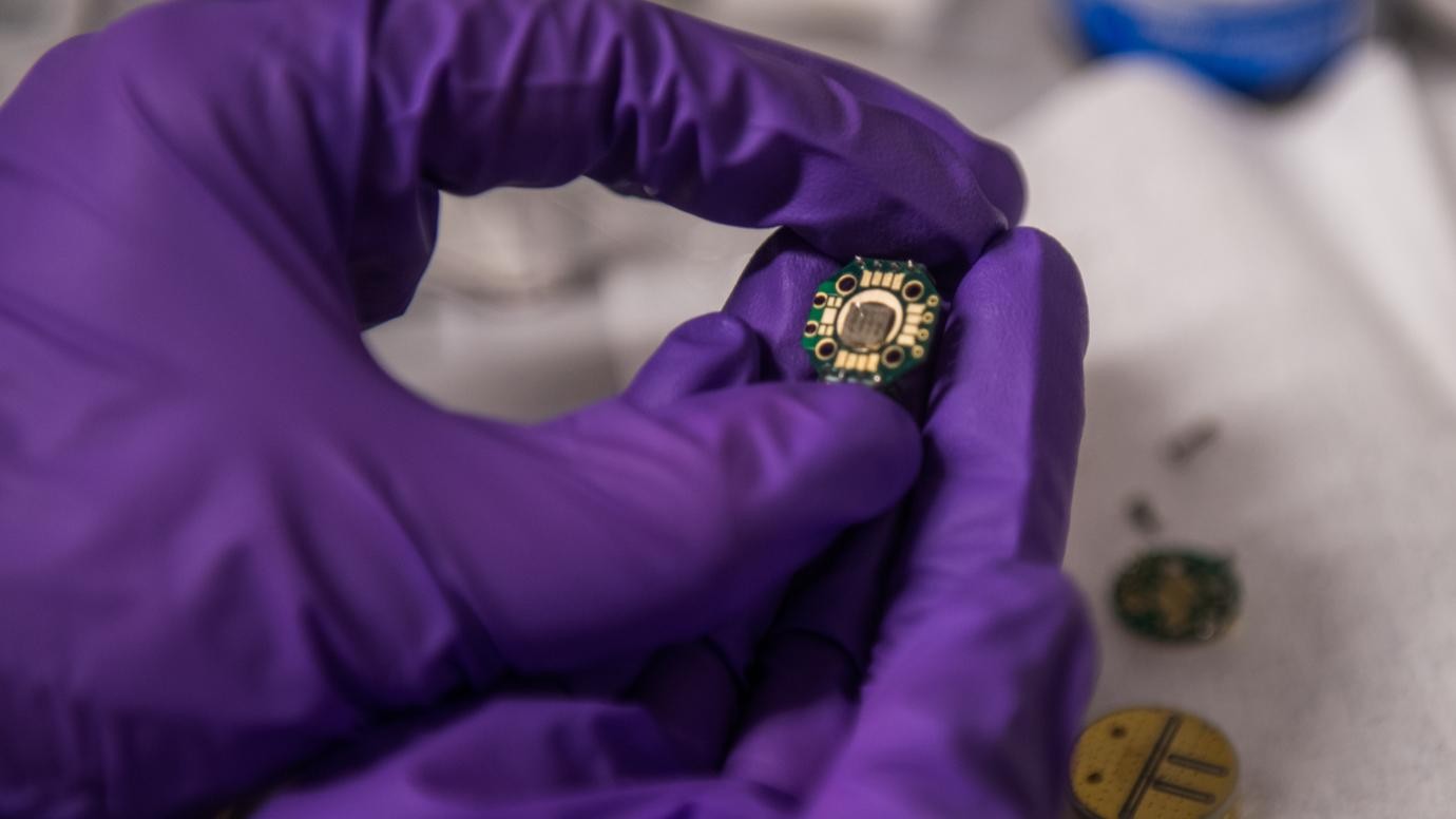 A student holds experimental quantum technology in the laboratory of Prof. David Awschalom at the University of Chicago. @ Jean Lachat