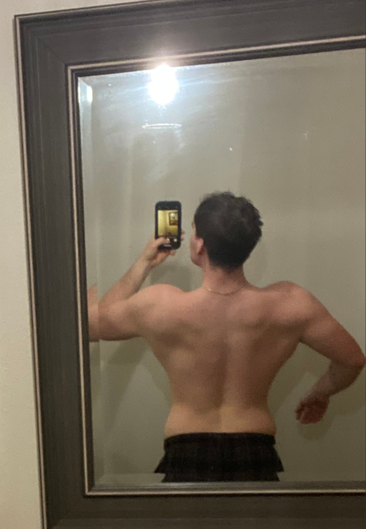 Posing in the mirror showing weight loss after starting TRT