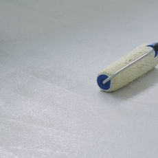 Moisture barrier epoxy primer applied to concrete before flake coating