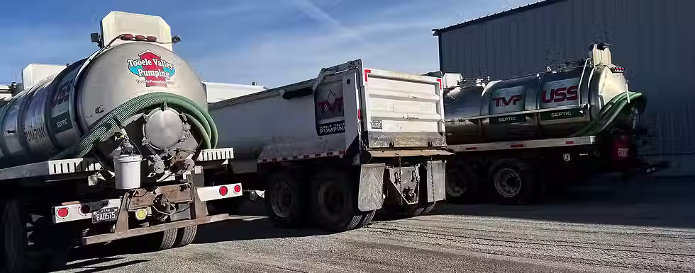 Two septic pumping trucks positioned neatly for easy access in a service area.
