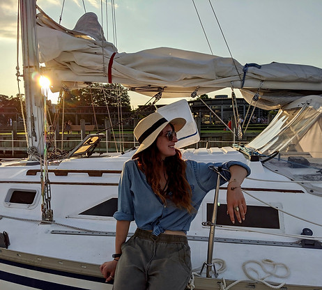 Woman sitting on a sailboat at sunset