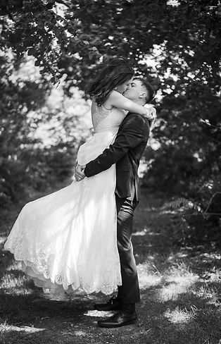 Groom carrying bride and they are sharing a kiss. black and white photo..JPG