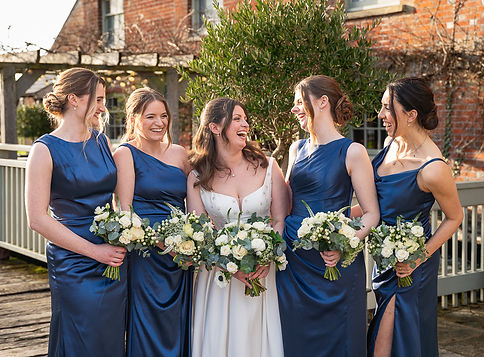 Bride and bridesmaids laughing in a group photo. Sopley Mill wedding venue..JPG
