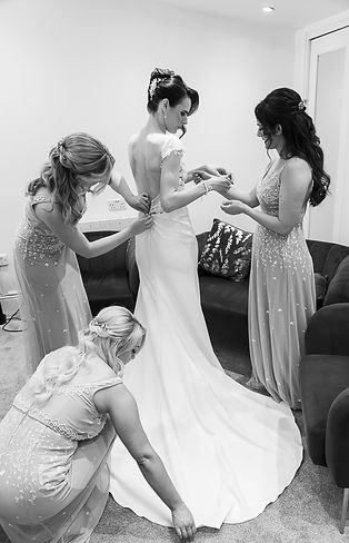 Bridesmaids helping bride to get ready.JPG