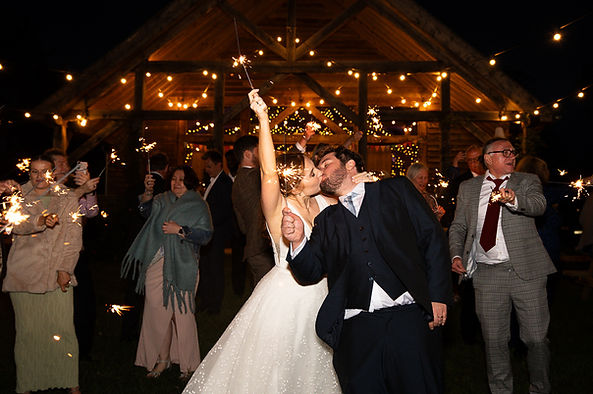 Bride and groom kissing whilst holding sparklers. The cedar roof barn wedding venue..JPG