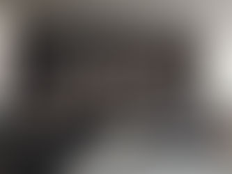 Moderan minimalistički spavaći prostor sa velikim garderoberom sa staklenim vratima, drvenim panelima, ugrađenim osvetljenjem i uredno organizovanom garderobom, koji odiše elegancijom.