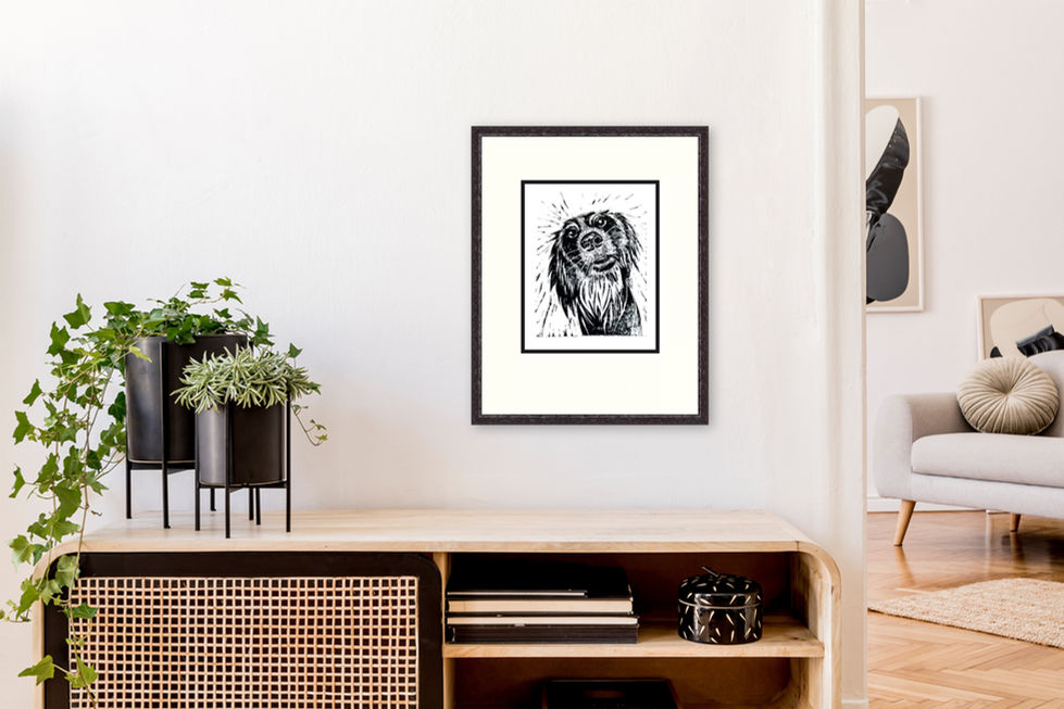 Framed dog illustration on wall above wooden shelf.