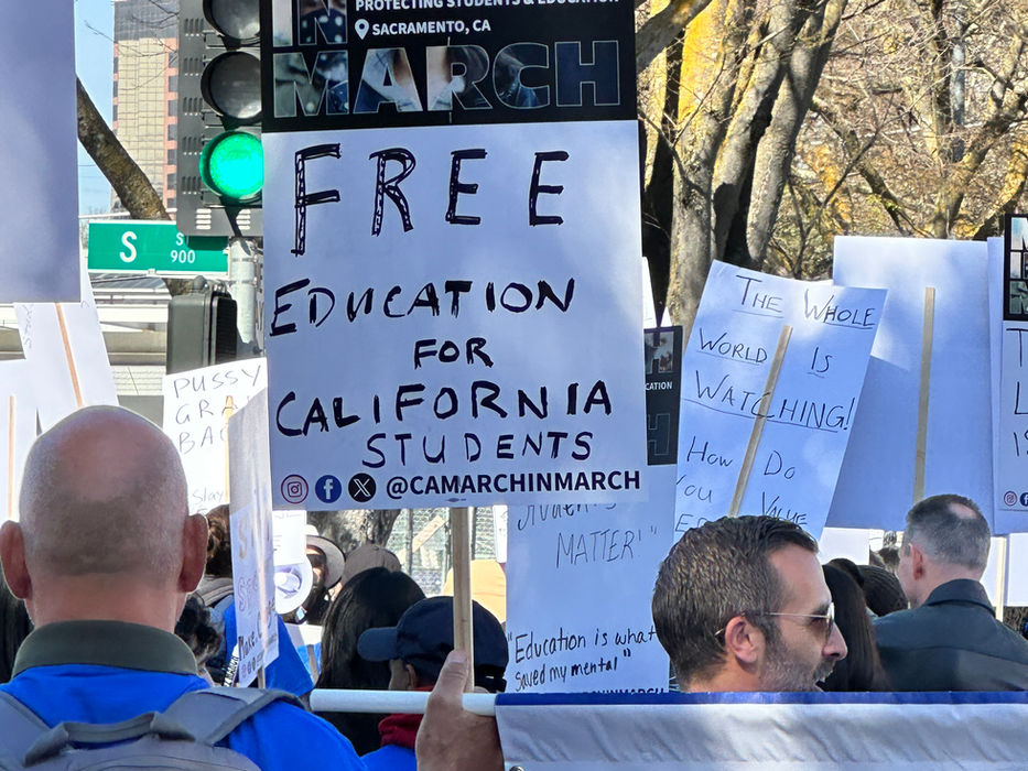 People at march hold "MARCH FOR" and "FREE EDUCATION FOR CALIFORNIA STUDENTS" signs.