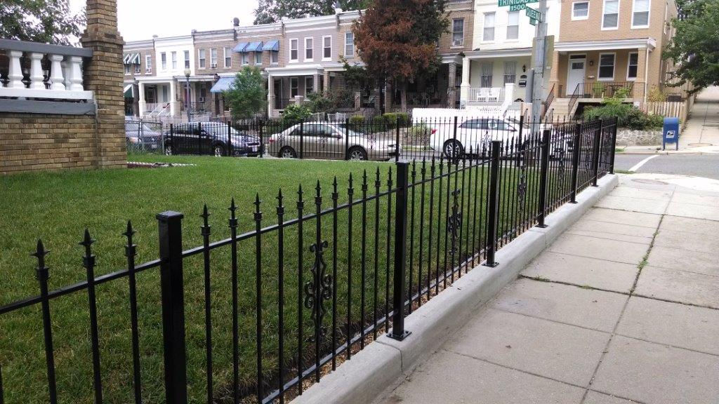 Residential black metal fence with sidewalk