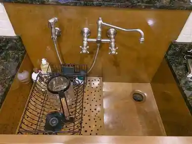 22 year old Rachiele custom apron front sink with full copper backsplash and wall mounted faucet