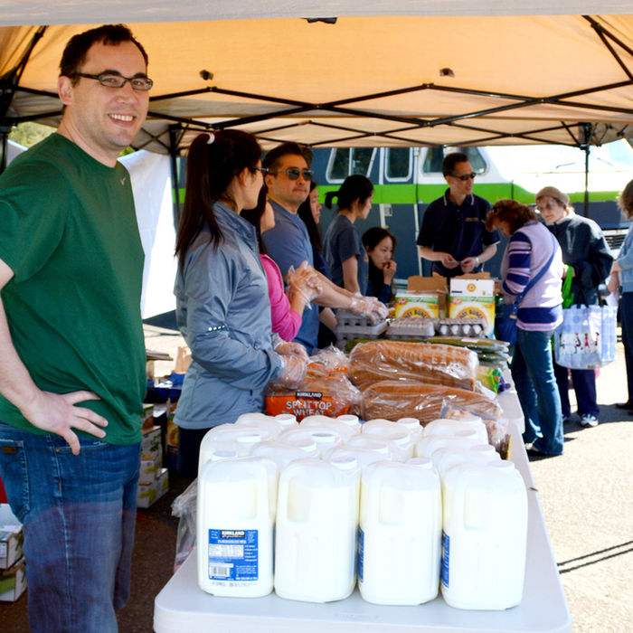 Volunteers providing groceries; milk, bread, and eggs. Food Distribution at community event.