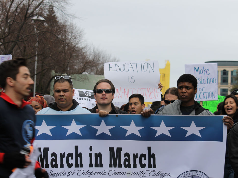 People marching, holding "March in March" banner for California Community Colleges.