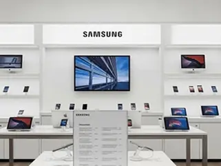 Cell phone store employee cleaning checkout counter and wiping demo phones to meet retail store cleaning standards