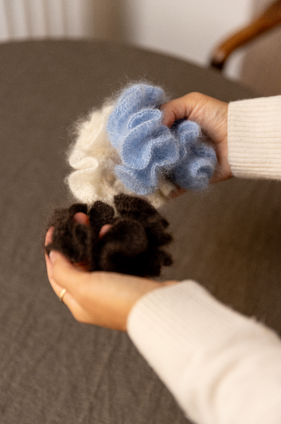 Three alpaca wool scrunchies in cream, blue, and brown held in hands Set of handmade crocheted scrunchies made from brushe