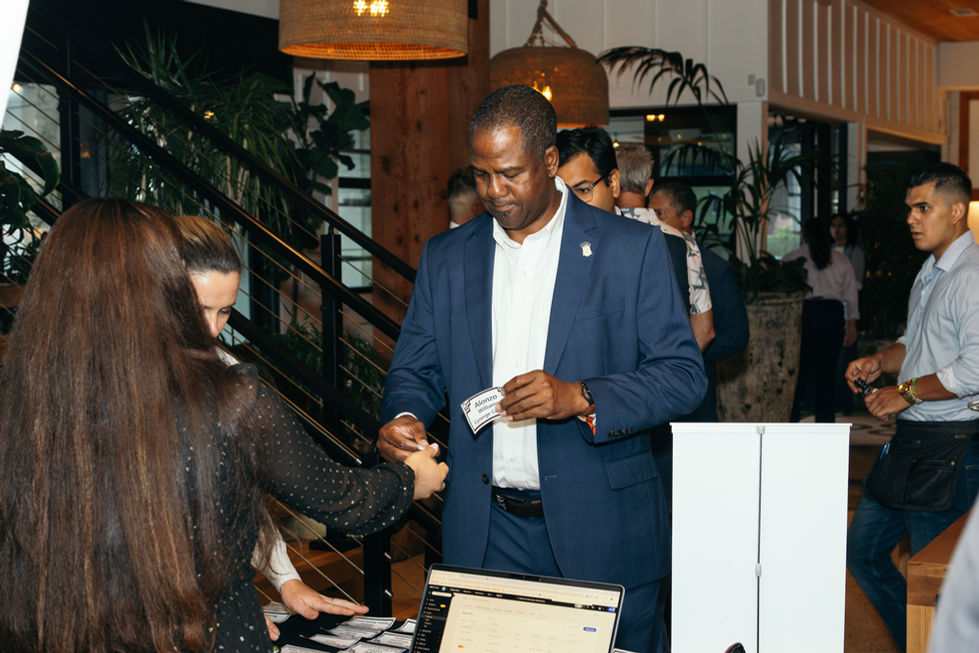 Man in suit exchanging items at an event.