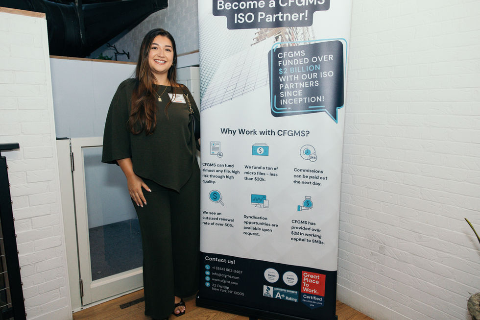 Woman standing beside a business banner display.