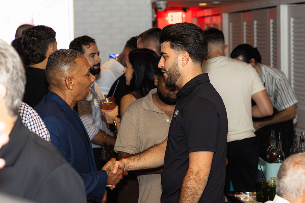Two people shaking hands at a social event.