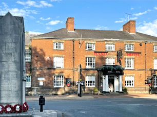 Historic front façade of The Hand Hotel in Chirk, a 17th-century coaching inn with original period features.