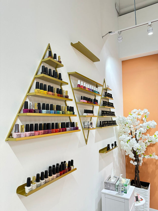 Triangle shelves full of various types of nail polish 