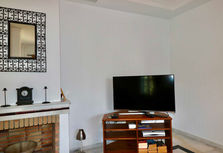 Fireplace and TV area inside a bright Andalusian home near the Atlantic.