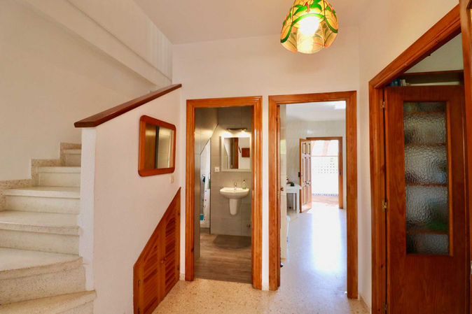 Ground floor hallway with stairs and warm light at the entrance of the house.