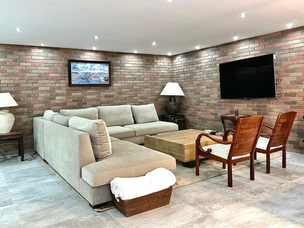 Living area with sectional sofa and brick walls.
