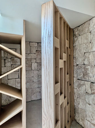 Interior niche with natural stone finish and vertical storage shelves.