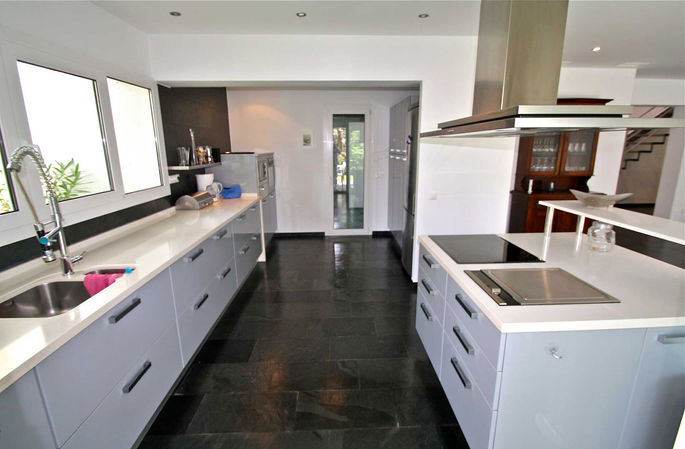 Open-plan modern kitchen with island and slate floor
