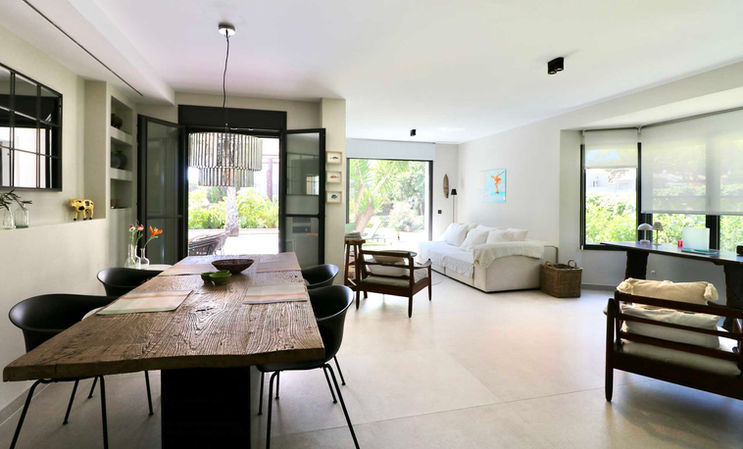 Modern open-plan living area with natural tones and full-height windows.