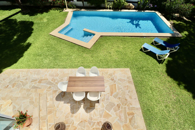 Terrace overlooking pool and lawn, ideal for outdoor meals.