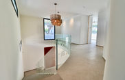 Bright double-height space with chandelier above elegant staircase in Roche, Conil de la Frontera.