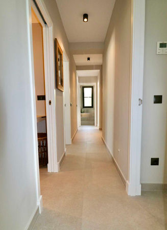 Corridor with neutral tones and large-format flooring.