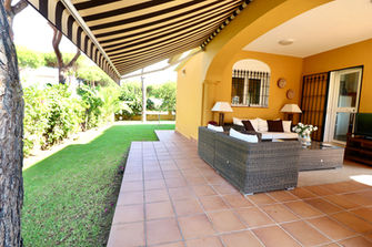 Cozy terrace under awning surrounded by lawn and pines near Conil de la Frontera.