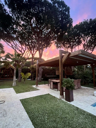 Wooden pavilion and outdoor lounge area in a garden in Roche