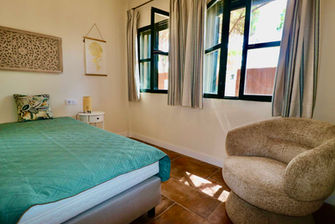 Cozy double bedroom with modern decor and large windows.