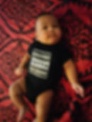 baby wearing straight outta da womb baby onesie lying on blanket