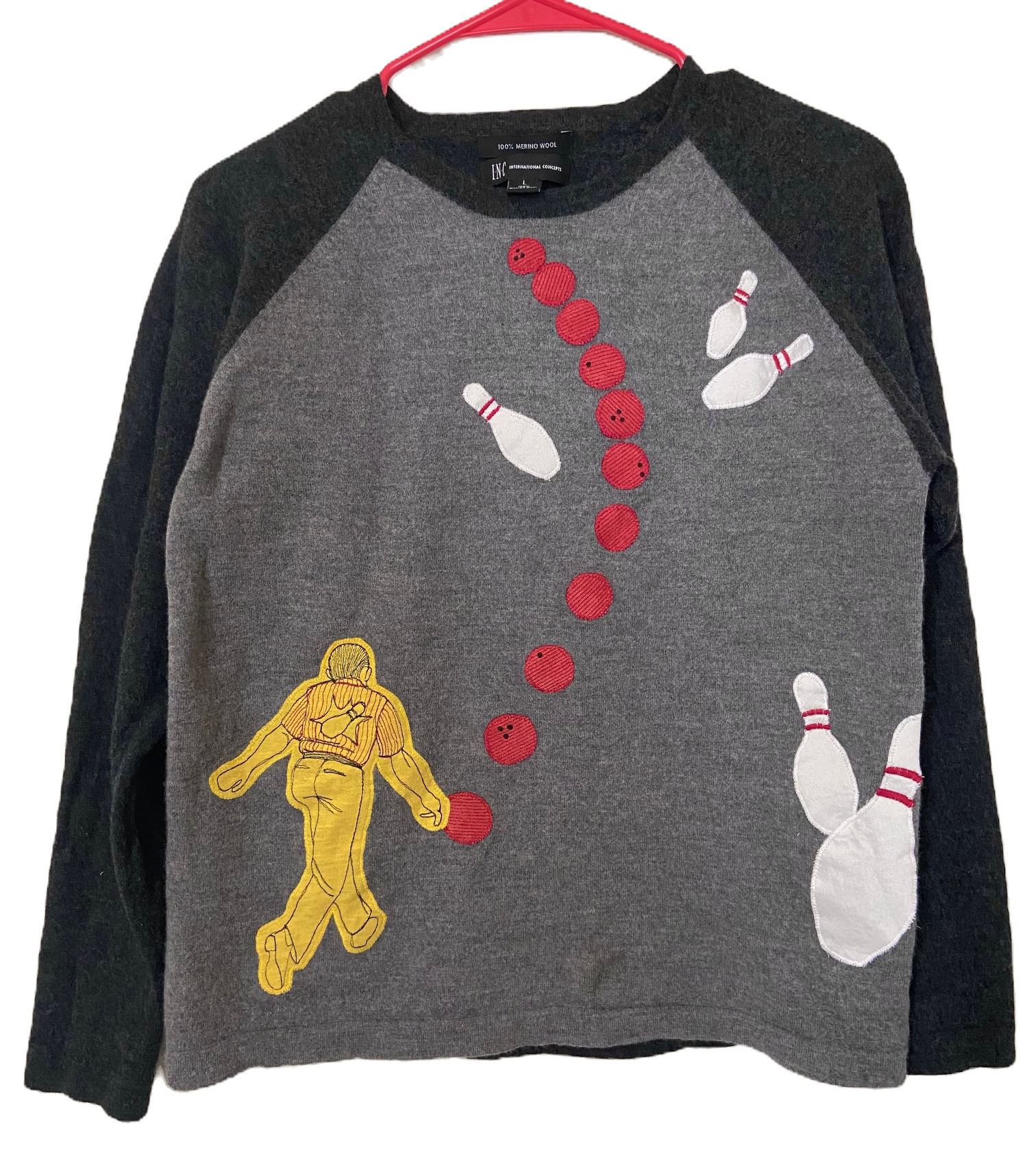 Black sleeve, gray merino wool sweater with applique bowler throwing a bowling ball into bowling pins