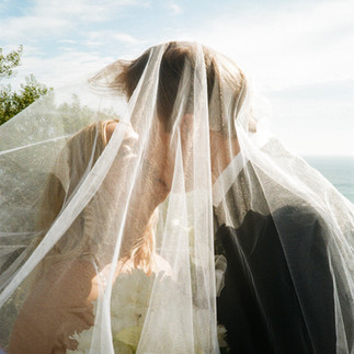 film photo of wedding couple kissing under veil