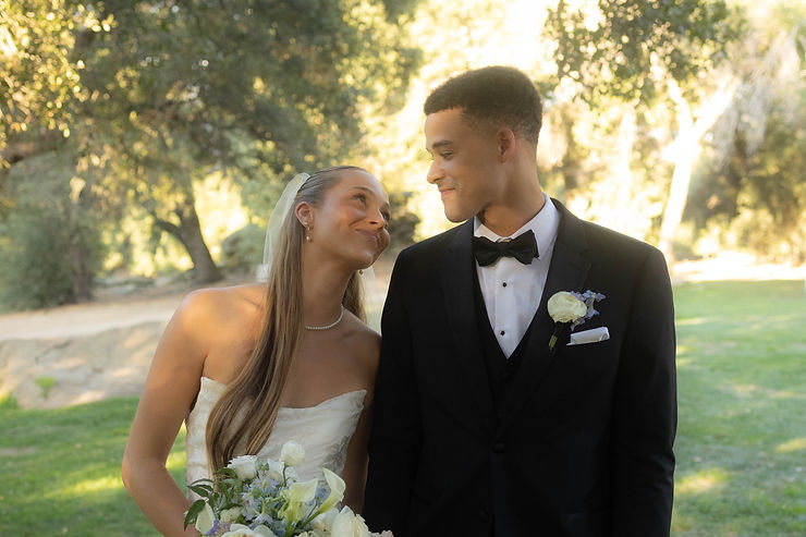 Bride playfully leaning on groom while smiling