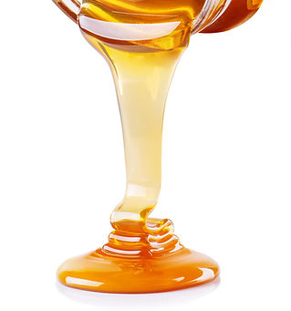 Honey flowing from the jar isolated on w