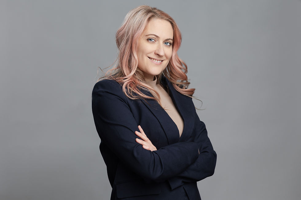 Woman with pink hair in blazer, smiling