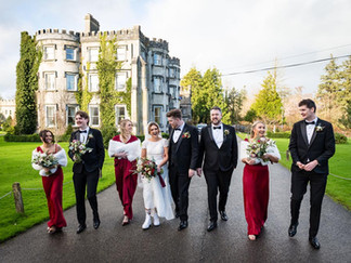 a wedding party walk together past ballyseede castle