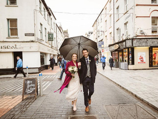 a bride and groom walk through Cork City after their winter wedding ceremony